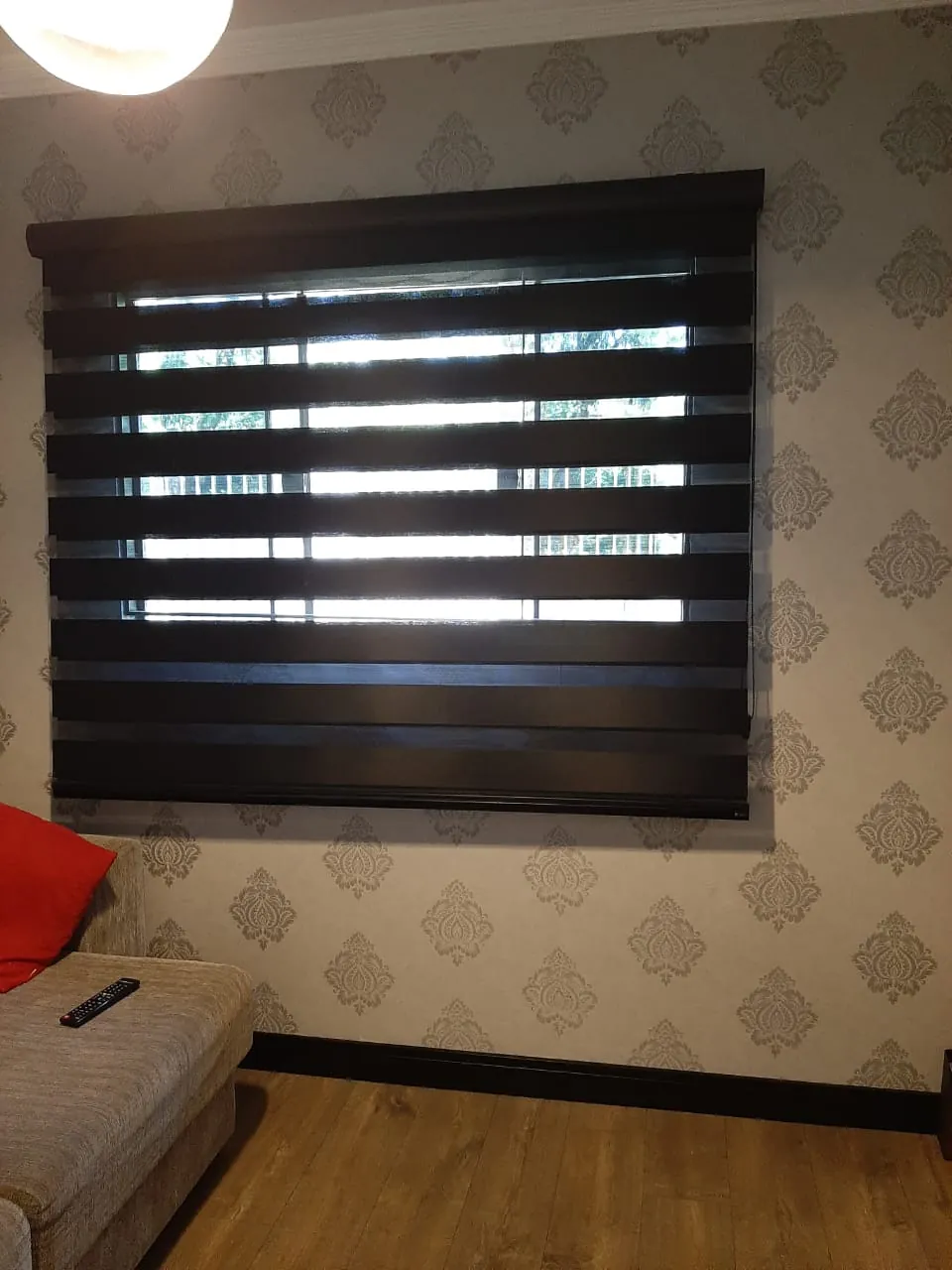 Persiana rolô escura em janela de quarto